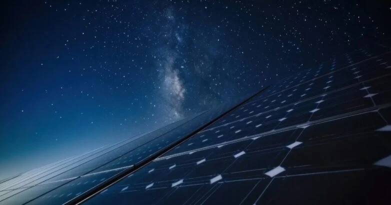 Long-exposure night shot of solar panels under a starry sky with faint moonlight glinting off glass