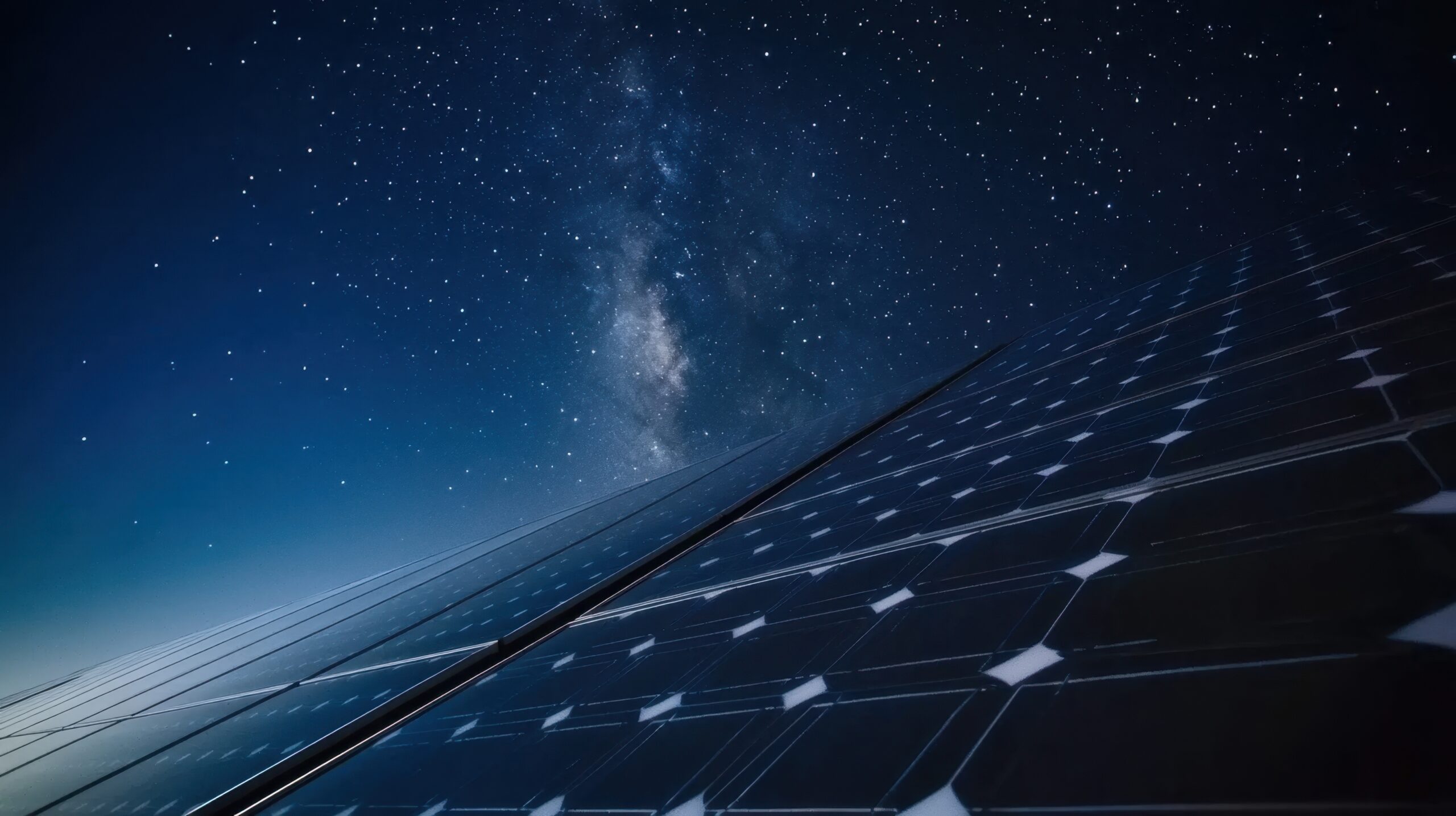 Long-exposure night shot of solar panels under a starry sky with faint moonlight glinting off glass