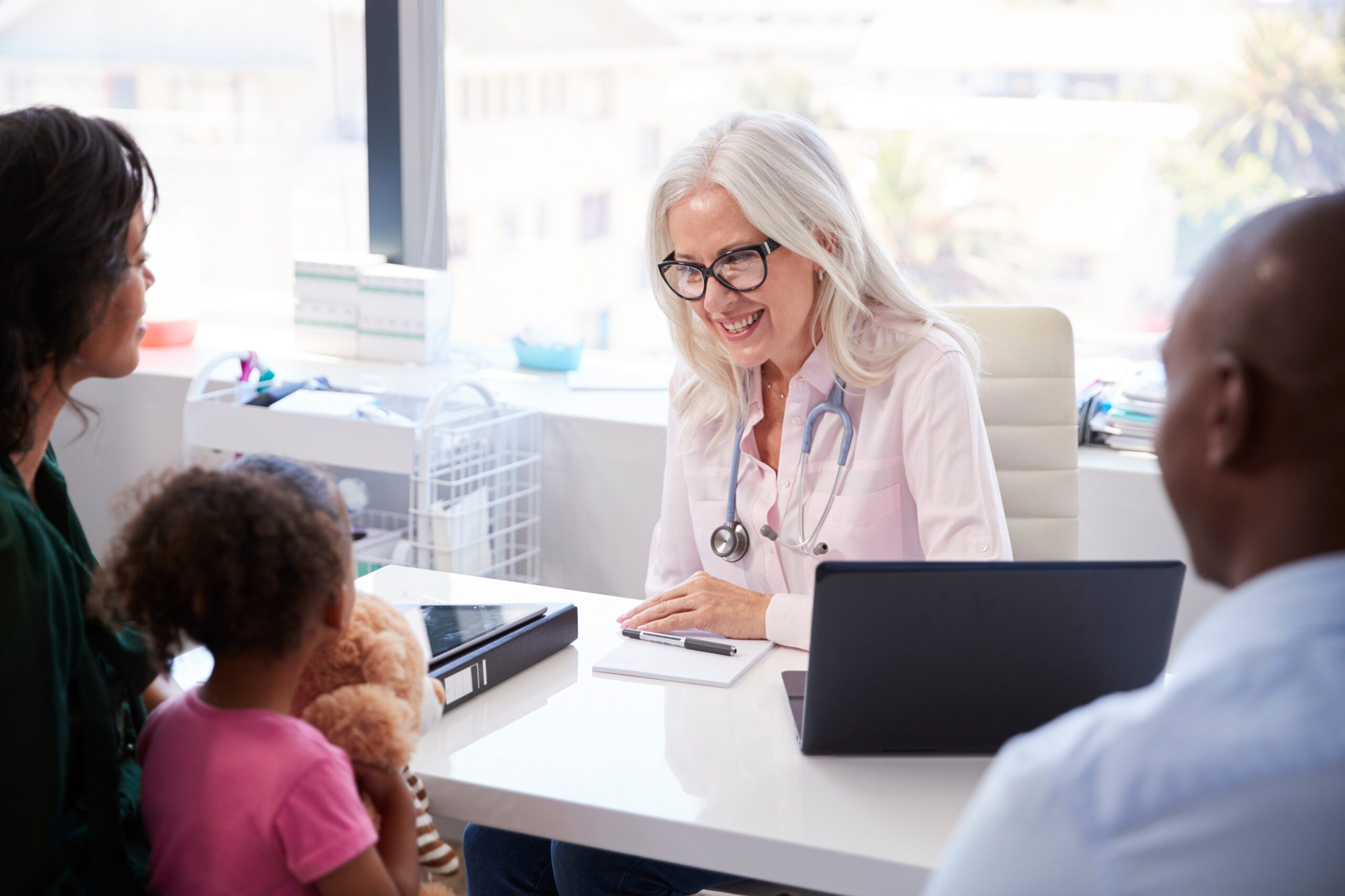 Family With Daughter In Consultation With Doctor In Office