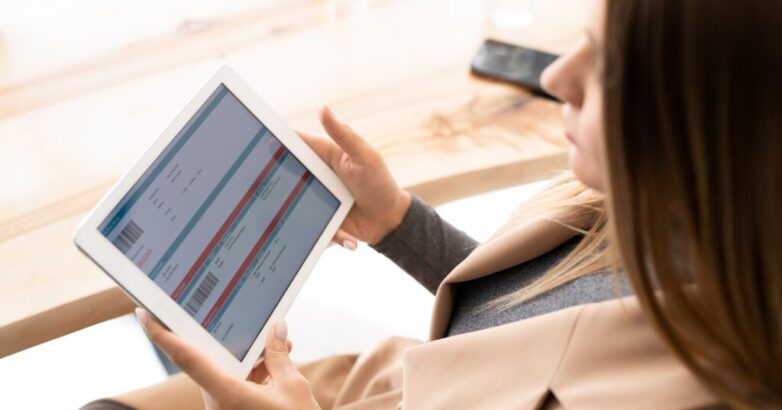 Young elegant businesswoman looking through online financial information