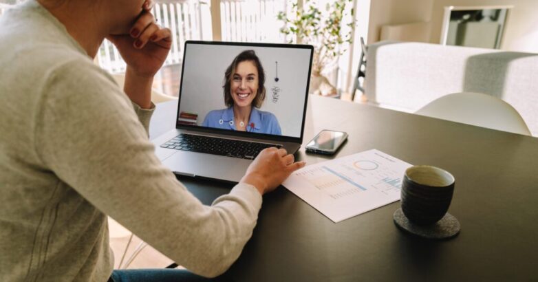 Woman teleconferencing with female colleague on laptop