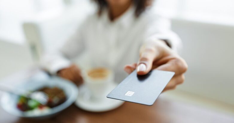 Portrait of african american woman paying in cafe with credit card