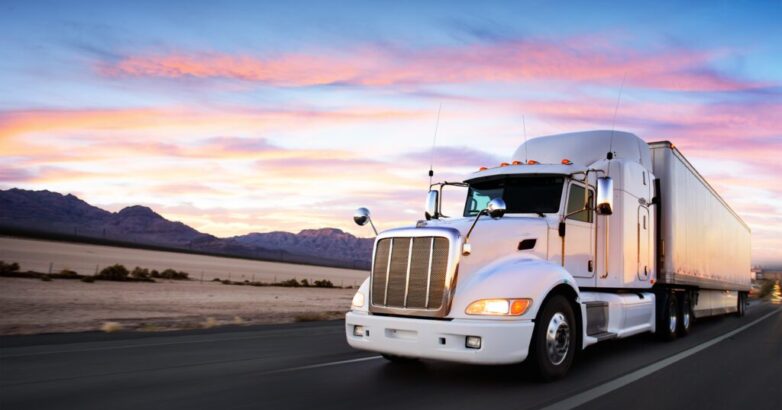 Truck and highway at sunset - transportation background