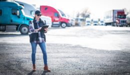 Woman truck driver transportation professional walking in truck yard