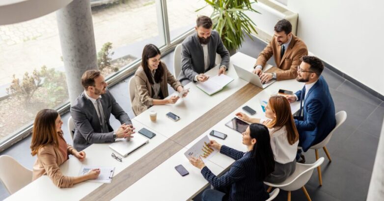 Top view of group of businesspeople sitting at boardroom and discussing data analytic.