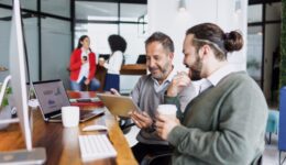 Latin senior man manager and young man employee working together on computer at creative office in Mexico Latin America, hispanic teamwork