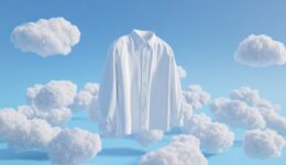 A white dress shirt floats among fluffy clouds in a bright blue sky, creating a dreamy and surreal atmosphere