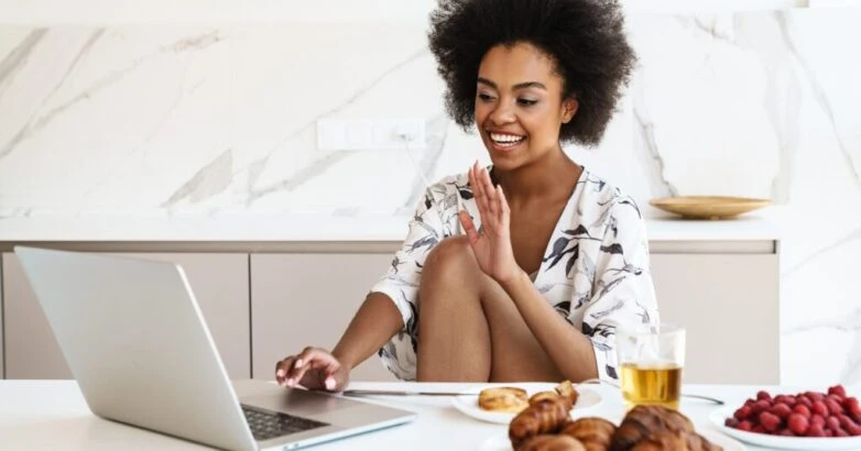 Cheerful beautiful woman using laptop